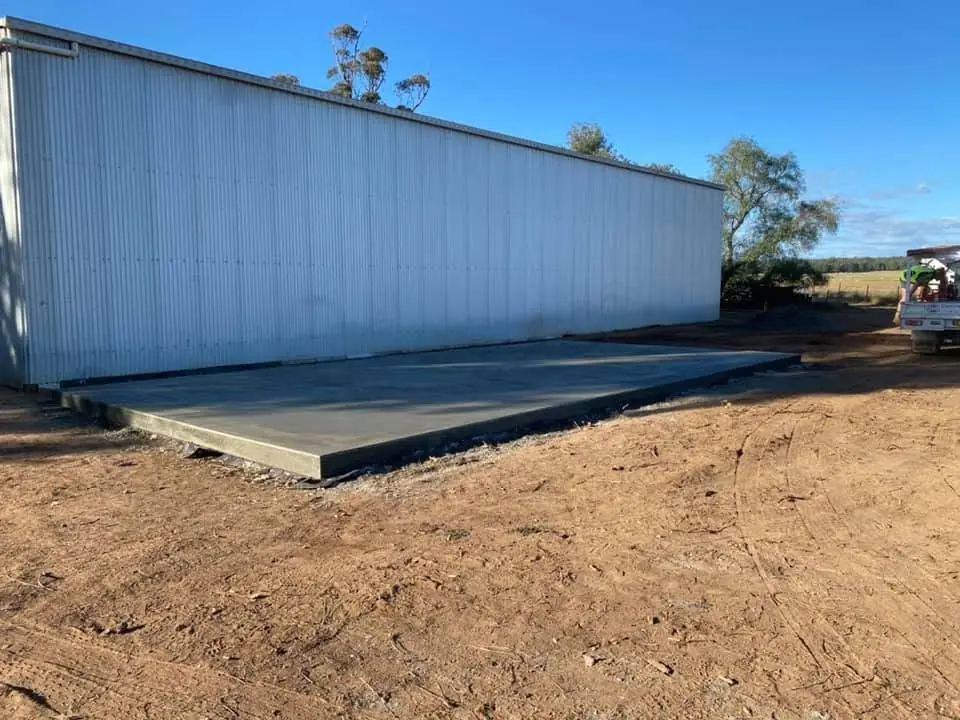 Fresh concrete slab along the side of a metal shed